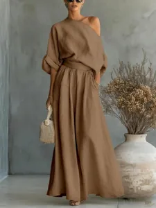 Detail view of a brown off-the-shoulder linen two-piece set with wide-leg pants.