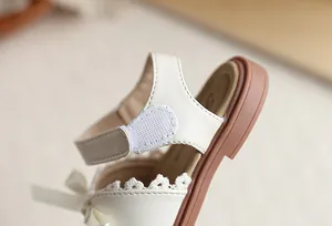 Vue détaillée de la sandale crème pour fille avec fermeture Velcro et bordure en dentelle