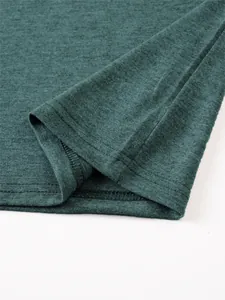 Zoom sur l'ourlet d'un t-shirt en lin vert foncé avec des coutures doubles précises