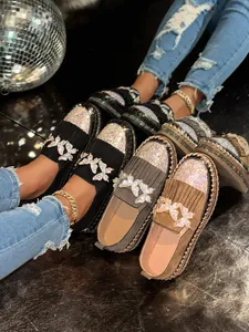 Detailansicht der Slipper mit funkelnden Strass-Schmetterlingen, Fransen und Plateausohle