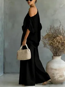 Side view of a woman in a black off-shoulder top and wide-leg trousers set