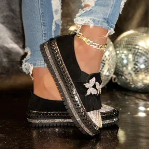 Detailansicht der schwarzen Plateau-Loafer mit glitzernden Schmetterlingen und Fransen