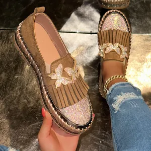 Detailansicht brauner Plateau-Loafer mit Strass-Schmetterlingen und Fransenverzierung.
