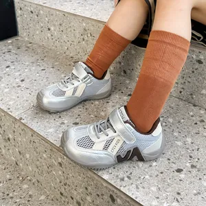 Gros plan sur les baskets de sport argentées en maille respirante pour enfants sur escalier