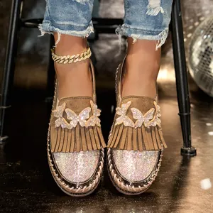 Detail von braunen Wildleder-Loafers mit Strass-Schmetterlingen und Fransen