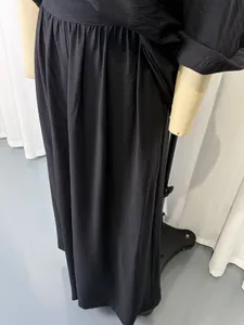 Detail view of the black off-shoulder two-piece set with an elegant fabric drape.