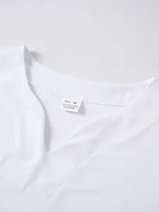 Détail du col en V d'un t-shirt blanc pour homme montrant l'étiquette de composition