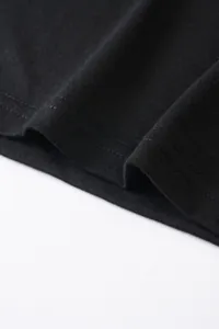 Gros plan du tissu en coton respirant et des surpiqûres de l'ourlet d'un t-shirt noir