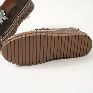 Detailansicht der rutschfesten Gummisohle von Plateau-Loafers mit Strass-Schmetterling.