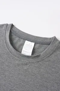 Gros plan d'un col de t-shirt gris montrant une étiquette d'entretien blanche et le tissu