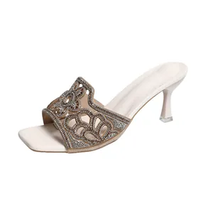 Mules élégantes à talons hauts avec des motifs floraux en strass complexes sur un bout carré.