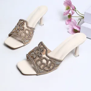 Vue détaillée de mules élégantes crème avec des brides à strass fleuris scintillants.