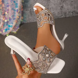 Vue détaillée des sandales à talons hauts blanches avec des motifs floraux en strass