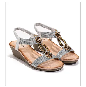 Close-up of Bohemian vintage wedge sandals with metallic weave and floral rhinestones