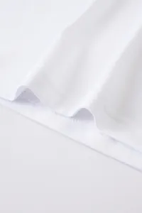 Vue détaillée en gros plan des coutures à double aiguille sur l'ourlet d'un t-shirt en coton lin.