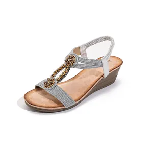 Bohemian ethnic wedge sandals with wooden flower buckle and elastic strap decoration.