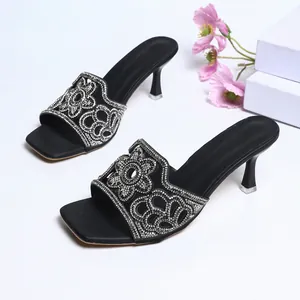 Vue détaillée d'élégantes sandales noires à talons hauts avec motifs floraux en strass