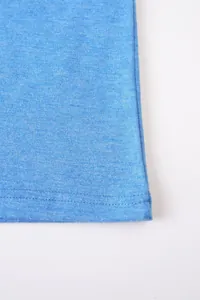 Gros plan de l'ourlet durable à double couture sur une chemise en coton bleu.