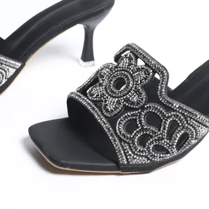 Vue détaillée d'élégantes sandales noires à talons hauts avec fleurs en strass