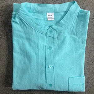 Dettaglio della maglia Henley in lino turchese da uomo con etichetta taglia M e trama.