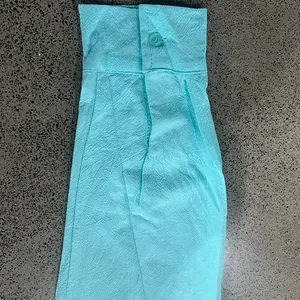 Primo piano della trama del polsino di una camicia in lino azzurro chiaro con bottone