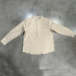 Vista dettagliata di una maglia Henley beige a maniche lunghe in lino da uomo con taschino