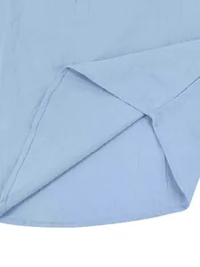 Dettaglio ravvicinato di una camicia in lino azzurro con cuciture su orlo e trama