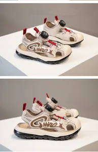 Detail view of boys' beige closed-toe beach sandals with rotating buckle system