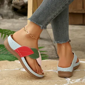 Vista lateral de sandalias de cuña con diseño de hojas multicolores y suelas gruesas