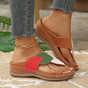 Detalle de sandalias de cuña modernas con diseño de hojas de colores y pespuntes