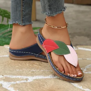 Detalle de sandalias con cuña para mujer con diseño de retazos de hojas de colores