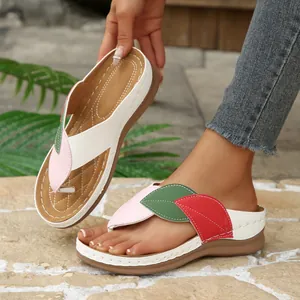 Detalle de diseño de hoja colorida en sandalias de cuña blancas para mujer con suela gruesa