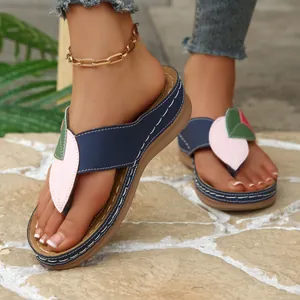 Detalle de sandalias con cuña para mujer con diseño de hojas de colores y suela gruesa