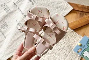 Detail view of pink girl's sandals with double bowknot and floral insole design.