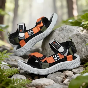 Outdoor-Sandalen für Kinder mit orangefarbenen Klettriemen auf Steinen im Freien
