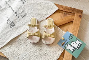 Detail view of cute girls yellow sandals with double bows and floral print insole