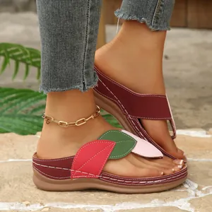 Detalle de sandalias de cuña para mujer con patchwork de hojas de colores y plataforma.