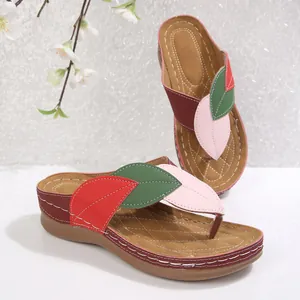 Vista detallada de las correas en forma de hoja colorida en sandalias de cuña para mujer