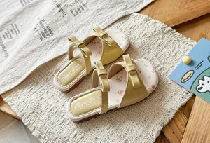 Detail view of yellow girls' sandals with bow accents and floral print insole.