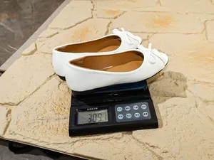 Detailed weight measurement showing white bow ballet flats on a digital scale at 309.1g