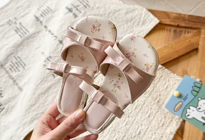 Close-up detail of pink girls summer sandals featuring bow decoration and floral pattern insoles