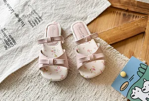 Detailed view of pink girls' princess sandals with dual bows and floral print insoles.
