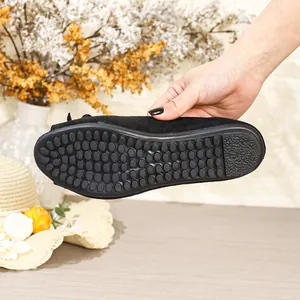 Close-up detail of the textured non-slip rubber sole on a black flat loafer shoe.