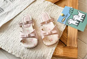 Detailed close-up view of the pink bow design and floral print on the toddler girl's sandal