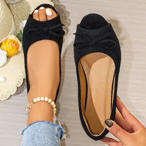 Elegant black peep-toe ballet flats with bow detail for a chic French summer look.