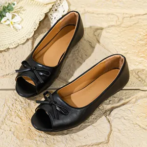 Detailed top view of black peep-toe flats with a stylish bow decoration