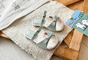 Detailed shot of sage green girls' summer sandals featuring floral footbed and sweet bow