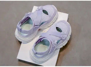 Detail view of purple girl's mesh sandals with floral accents and soft soles.
