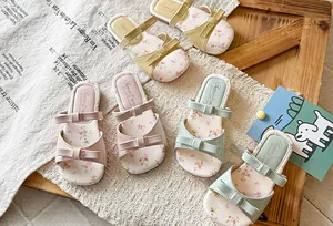 Close-up view of girls' summer bow sandals in pastel colors with cute floral printed insoles