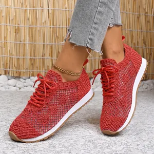 Close-up of breathable red mesh sneakers with floral pattern and lace-up design